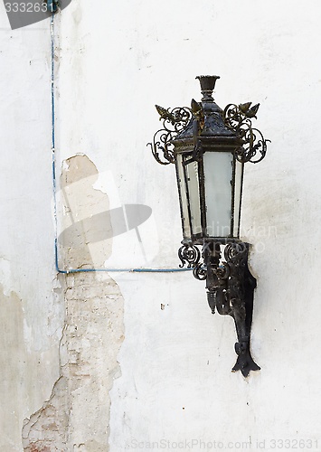 Image of Retro street lantern on peeling plaster wall