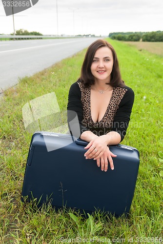 Image of Beautiful smiling woman with suitcase
