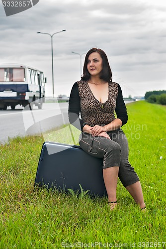 Image of Attractive woman sits on staircase near road