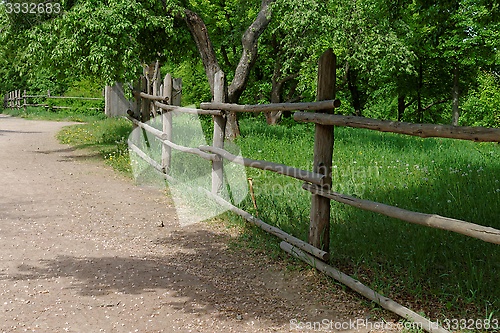 Image of Rural path enclosed with lath fence at summer