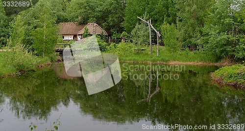 Image of Traditional farmer's house reflecting in a pond in open air museum, Kiev, Ukraine