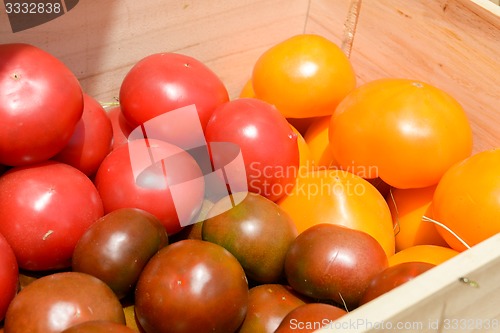 Image of red and yellow tomatoes in wooden crates