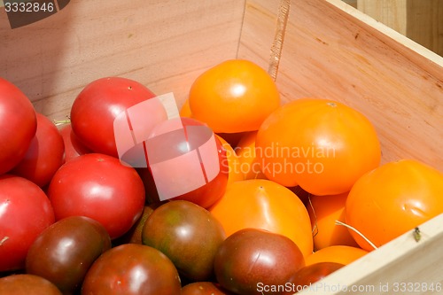 Image of red and yellow tomatoes in wooden crates