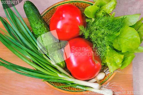 Image of Fresh vegetables: tomatoes, cucumbers, onions, lettuce.