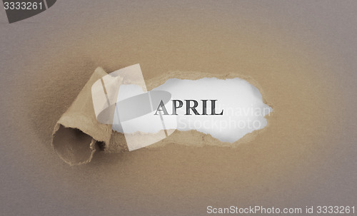 Image of Text appearing behind torn brown envelop