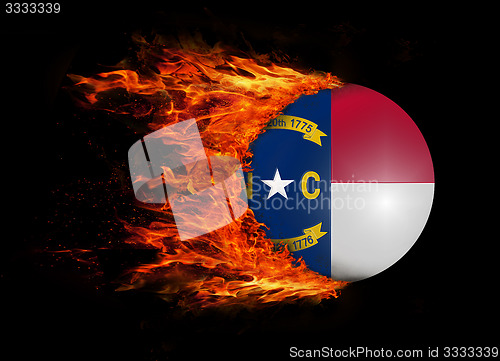 Image of US state flag with a trail of fire - North Carolina