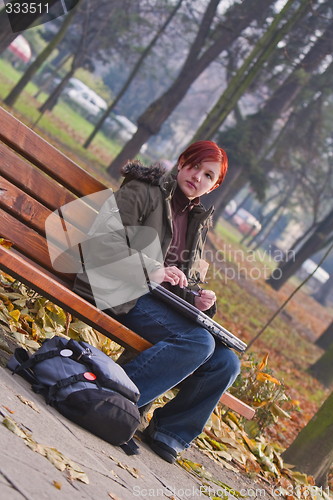 Image of Redheaded girl in an autumn park