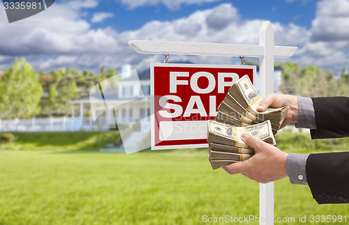 Image of Man Handing Over Money in Front House For Sale, Sign