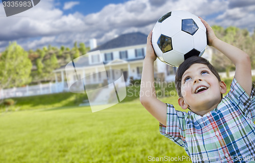 Image of Smiling Young Boy Holding Soccer Ball In Front of House