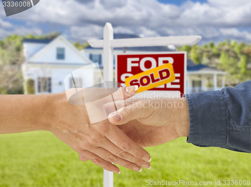 Image of Shaking Hands in Front of New House and Sold Sign