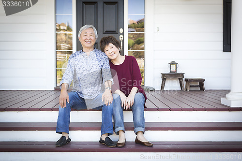 Image of Senior Chinese Couple Sitting on Front Steps of Their House