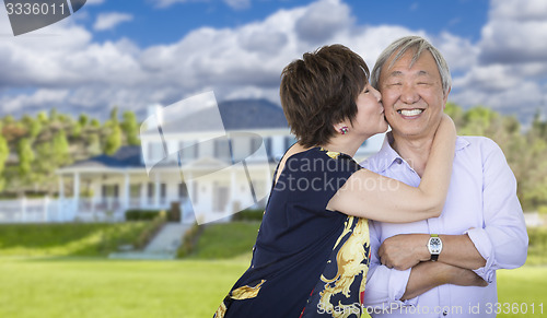 Image of Affectionate Senior Chinese Couple In Front of Beautiful House