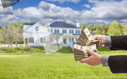 Image of Man Handing Over Hundreds of Dollars in Front of House