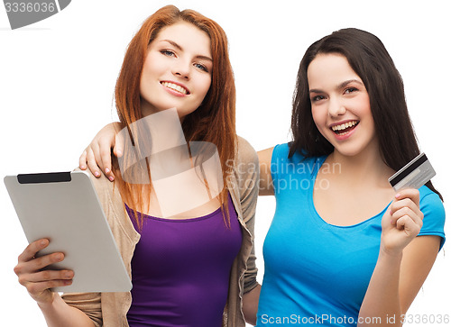 Image of two smiling girls with tablet pc and credit card