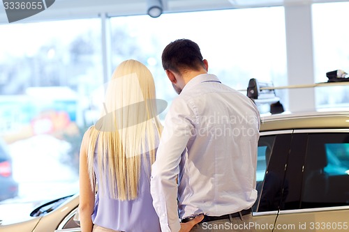 Image of couple buying car in auto show or salon