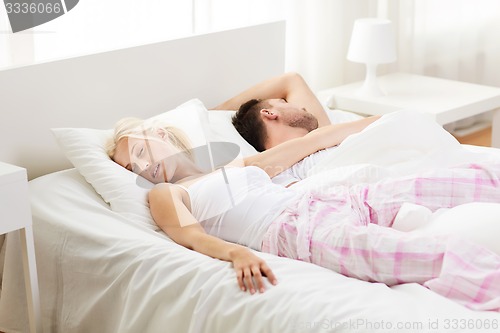 Image of happy couple sleeping in bed at home