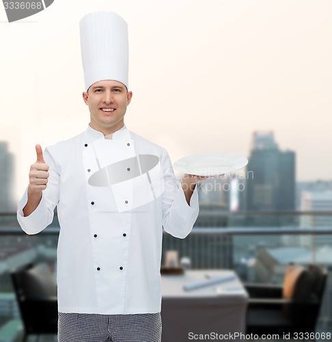 Image of happy male chef cook showing thumbs up and plate