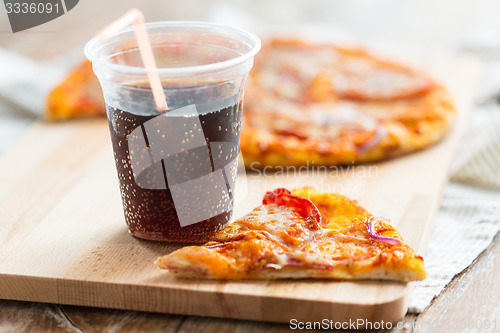 Image of close up of pizza with coca cola on table