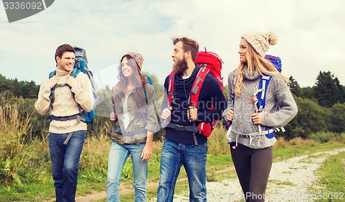 Image of group of smiling friends with backpacks hiking