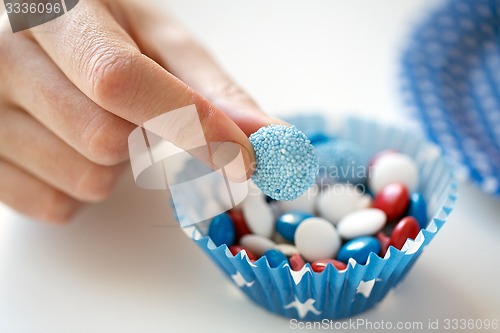 Image of close up of hand with candies on independence day