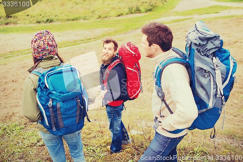 Image of group of smiling friends with backpacks hiking