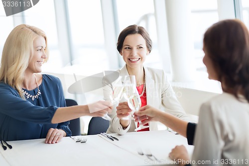 Image of happy women drinking champagne at restaurant