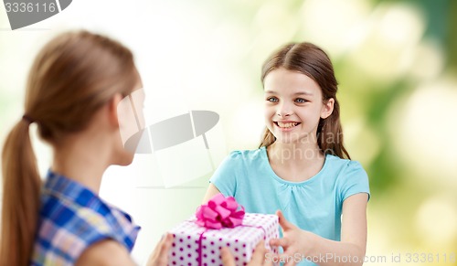Image of happy girls with birthday present over green