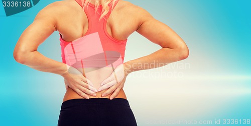 Image of close up of sporty woman touching her back