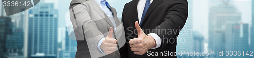 Image of businessman and businesswoman showing thumbs up