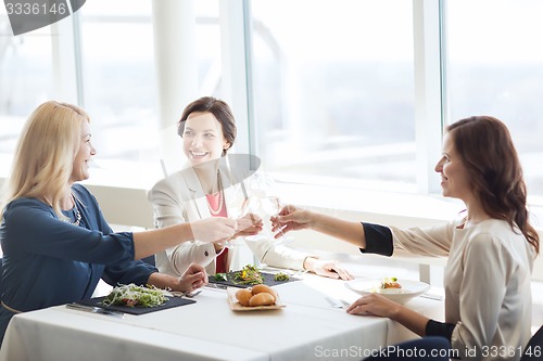 Image of happy women drinking champagne at restaurant