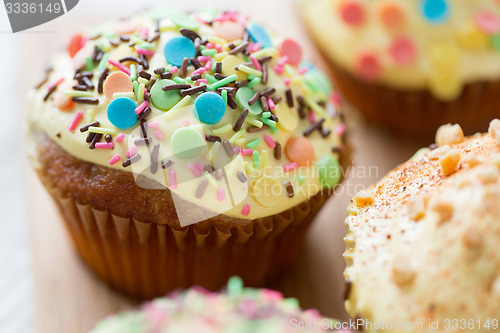 Image of close up of glazed cupcakes or muffins on table