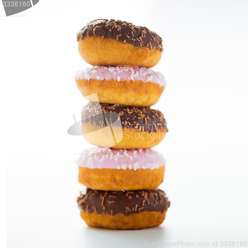 Image of close up of glazed donuts pile over white