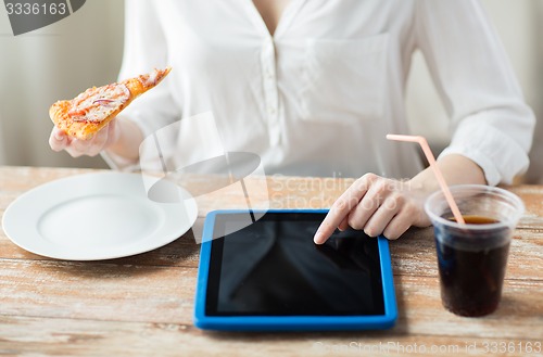 Image of close up of woman with tablet pc having dinner