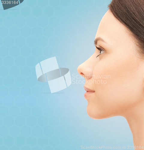 Image of beautiful young woman face over blue background
