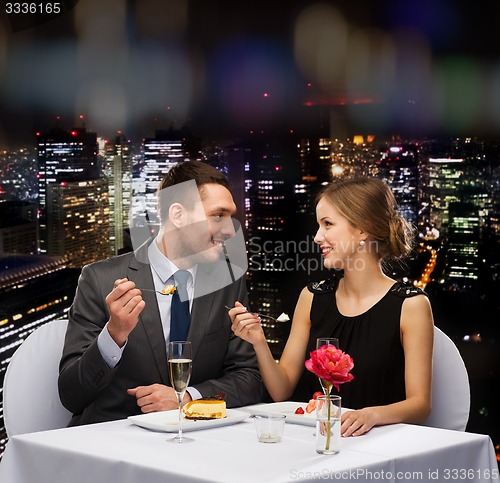 Image of smiling couple eating dessert at restaurant