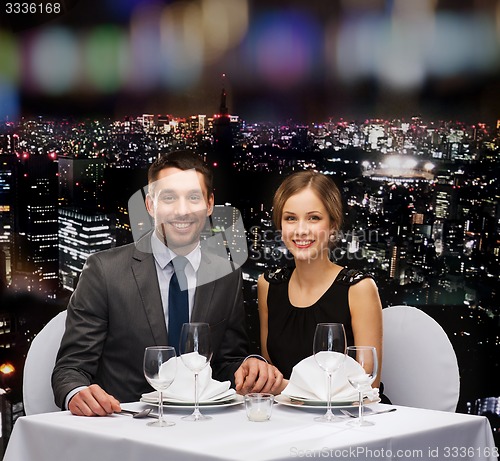 Image of smiling couple holding hands at restaurant