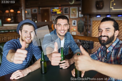 Image of happy male friends drinking beer at bar or pub