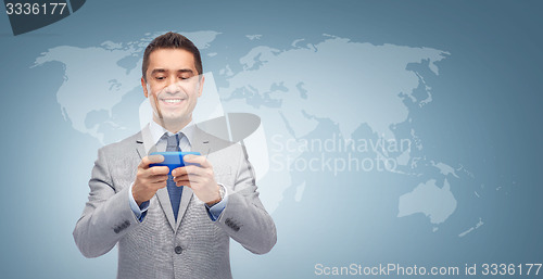 Image of happy businessman texting message on smartphone