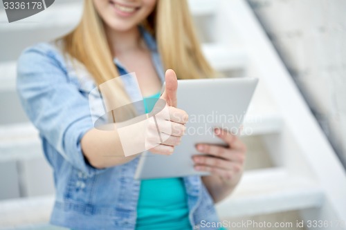 Image of close up of woman with tablet pc showing thumbs 
