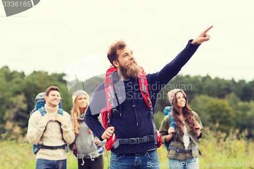 Image of smiling hikers with backpacks pointing finger