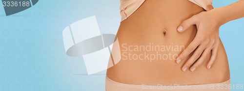 Image of close up of woman pointing finger to bare belly