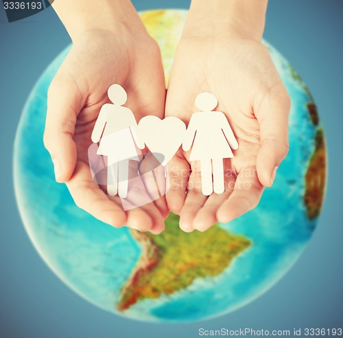 Image of female hands with paper gay couple figures