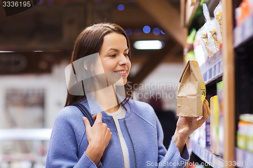 Image of happy woman choosing and buying food in market