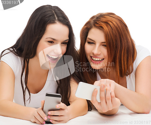 Image of two smiling teenagers with smartphones