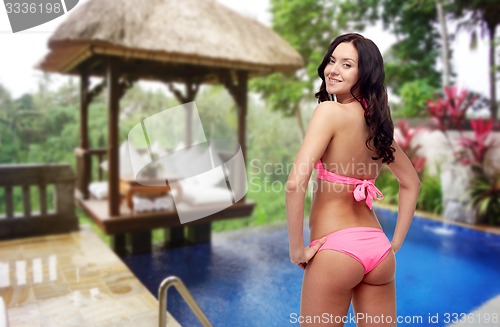 Image of happy young woman in pink bikini swimsuit