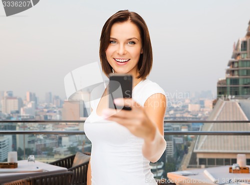 Image of woman taking selfie with smartphone over singapore