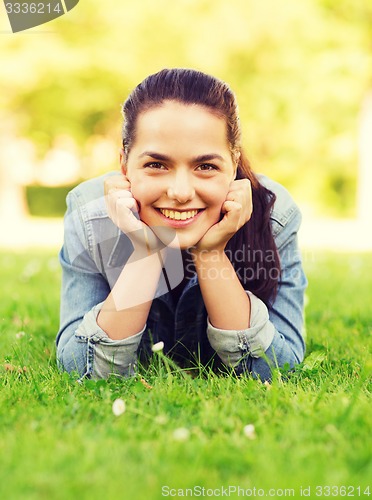 Image of smiling young girl lying on grass