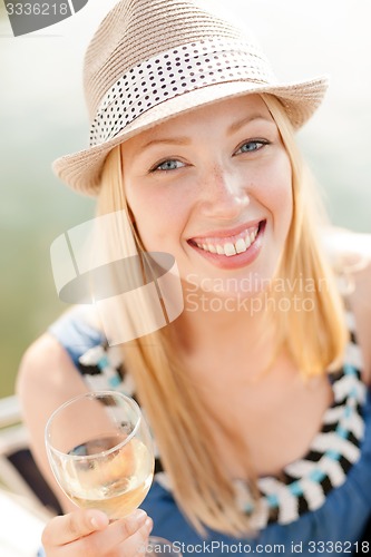Image of smiling girl in hat with champagne glass
