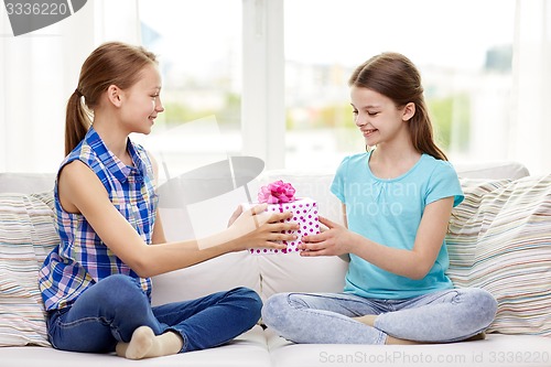 Image of happy little girls with birthday present at home