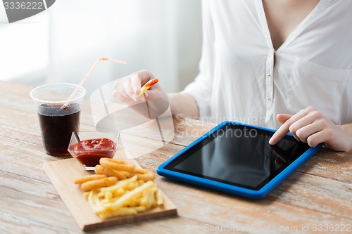 Image of close up of woman with tablet pc and fast food